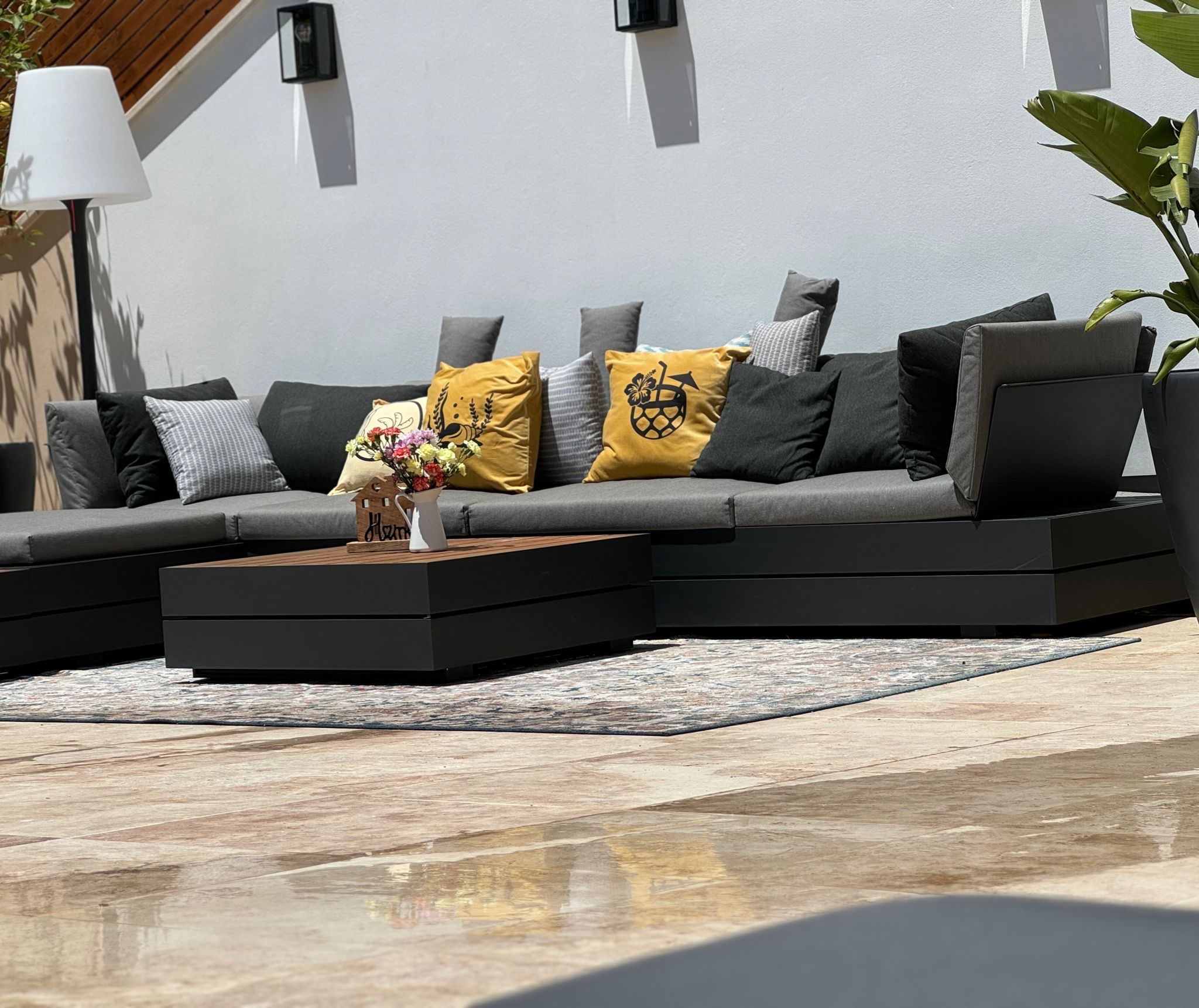 Zona lounge exterior con sofás y cojines bajo cielos mediterráneos