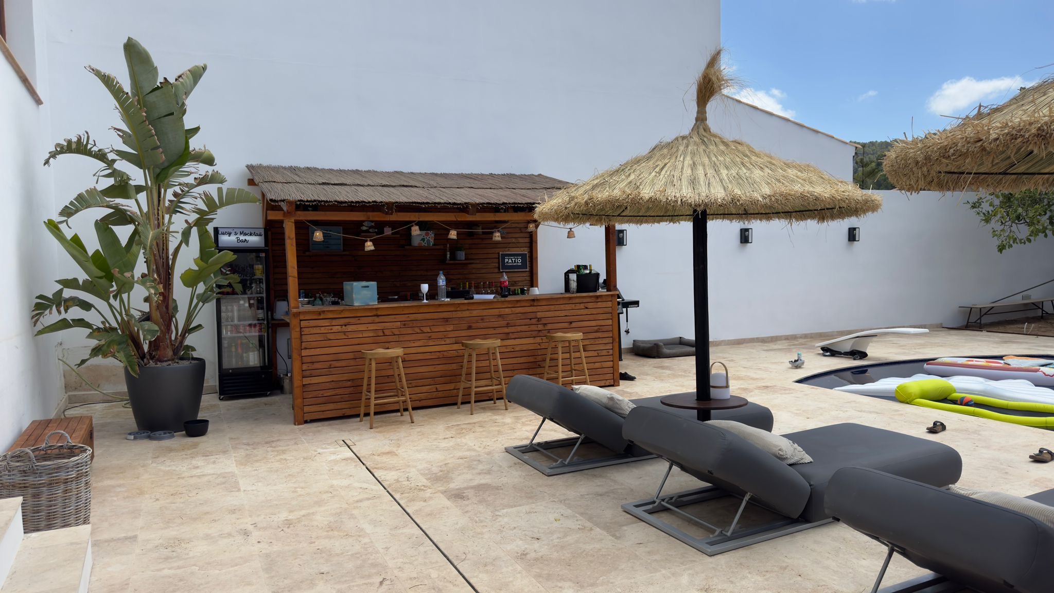 Área de piscina con bar de verano y tumbonas bajo el sol de Mallorca